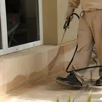 General pest control technician spraying exterior perimeter around a home in Philadelphia, PA